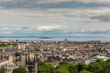 Edinburgh, İskoçya, İngiltere - 13 Haziran 2012: Calton Hill yoğun inceliyorlar Leith banliyösü Nord deniz giriş altında ağır bir cennet doğru inşa. Ada ve diğer tarafında su yatay çizgiler vardır.