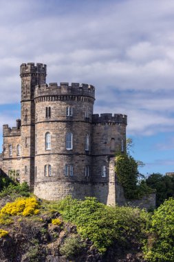 Edinburgh, İskoçya, İngiltere - 13 Haziran 2012: Closeup Vali evi eski Calton hapis üzerinde bulutlu gökyüzü altında yeşil uçurum.