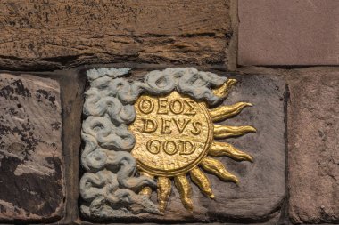 Edinburgh, Scotland, UK - June 13, 2012: Closeup of Golden Sun, named god and deus, on facade of John Knox House, a protestant reformer. clipart