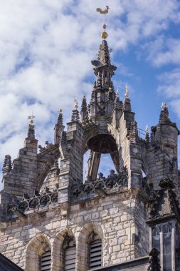 Edinburgh, İskoçya, İngiltere - 13 Haziran 2012; St Giles Katedrali. Closeup spire beyaz bulutlar ile mavi gökyüzü karşı tacı. Üst, gri taş yapısı üzerinde altın horoz.