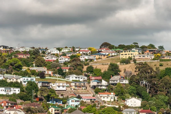 Burnie, Tazmanya, Avustralya - 15 Aralık 2009: Şehir görünümü gösterir koleksiyonu renkli evlerin altında koyu gri cennet yeşil tepe üzerinde ayarla. 