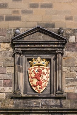 Edinburgh, İskoçya, İngiltere - 14 Haziran 2012: Closeup Kraliyet İskoç aslan amblemi, kalkan ve altın taç kahverengi taş Castle adlı bina ayarlamak ile.