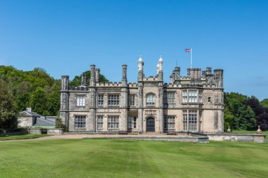 Edinburgh, İskoçya, İngiltere - 14 Haziran 2012: Yan cephe Dalmany evi, konak ve yeşil çim, İngiliz bayrağı ile ve mavi gökyüzü altında Tudor revival stil kalede.