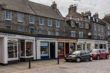 Queensferry, İskoçya, İngiltere - 14 Haziran 2012: Alışveriş High Street küçük mağazalar. dükkan kare boyalı. Üst katta, kahverengi taş. Arabalar ve gri sokak yüzey. Cennet.