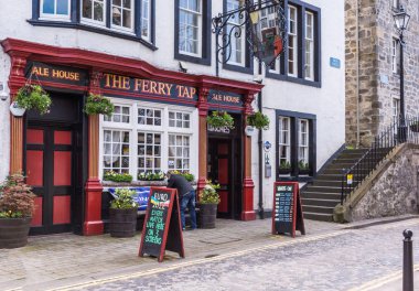 Queensferry, İskoçya, İngiltere - 14 Haziran 2012: Kırmızı ve siyah High Street feribot dokunun pub ale ev cephe boyalı. Çiçekler ve sokak çevreleyen, Duyurular.