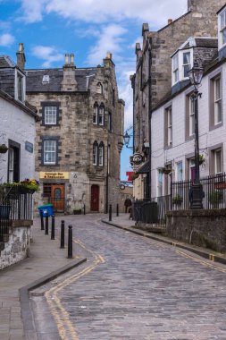 Queensferry, İskoçya, İngiltere - 14 Haziran 2012: Dar Edinburgh yol parçasını barlar evler ve kahverengi taş evlerin restoran arasında normal beyaz boyalı. Bazı mavi gökyüzü ve gri sokak kaldırım.