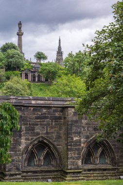 Glasgow, İskoçya, İngiltere - 17 Haziran 2012: Nekropolis. Kule John Knox Dikilitaş ve Duncan Macfarlan anıt üzerinde dinlenme üstünde tepe-in hill cennet altında. Kahverengi taş duvarlar ve yeşil bitki örtüsü.