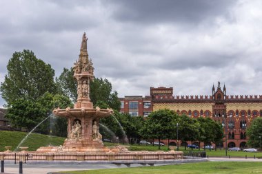 Glasgow, İskoçya, İngiltere - 17 Haziran 2012: Doulton Çeşme Glasgow yeşil ağır cennet altında. Yeşil yeşillik ve arka bina Pendleton.