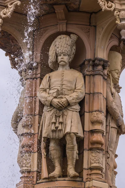 グラスゴー グリーン グラスゴー スコットランド イギリス 2012 ドルトン噴水 ビクトリア女王時代の兵士の茶色の石の彫像 噴水から流れ落ちる水を削除します 梅雨空 — ストック写真