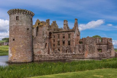Shearington, İskoçya, İngiltere - 18 Haziran 2012: Closeup Güney tarafı yıkık üçgen kahverengi taş Caerlavarock Castle kamaralar erken yerli klasik mimarisi ile moated.
