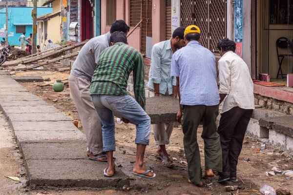 印度卡纳塔克邦的贝卢尔 1月2日 5个人处理躺着的重混凝土板 下来覆盖一条下水道线路 与人的街道场面 — 图库照片