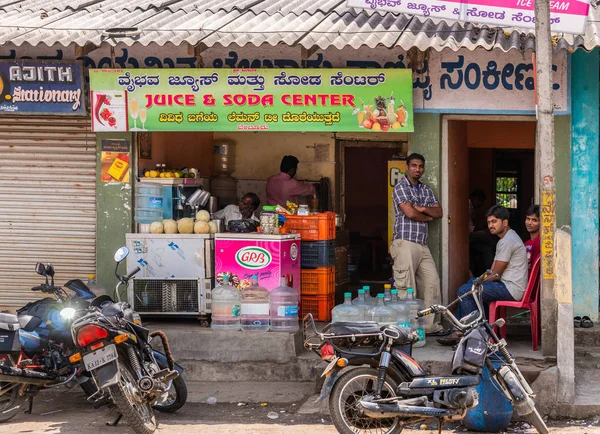 ベルール カルナタカ インド 2013 クローズ アップのジュースとソーダ センター小さな店の周りぶら下がっている男性とオートバイ フロントまで カラフルなバナー — ストック写真