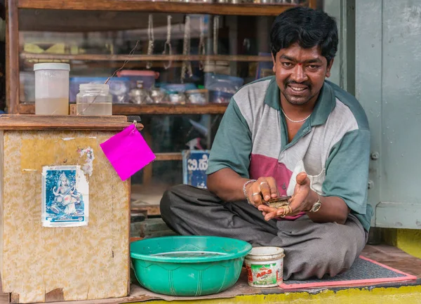 ベルール カルナタカ インド 2013 クローズ アップの宝石商の男彼の店の前で石鹸盆地におけるクリーニングの黄金色の宝石です 近くの女神サラスワティの画像 — ストック写真