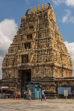 Belur, Karnataka, Hindistan - 2 Kasım 2013: Kahverengi taş Gopuram ana giriş, mavi gökyüzü Tapınağı içinde görüldü. Kabinleri, işaretler ve insanlar.