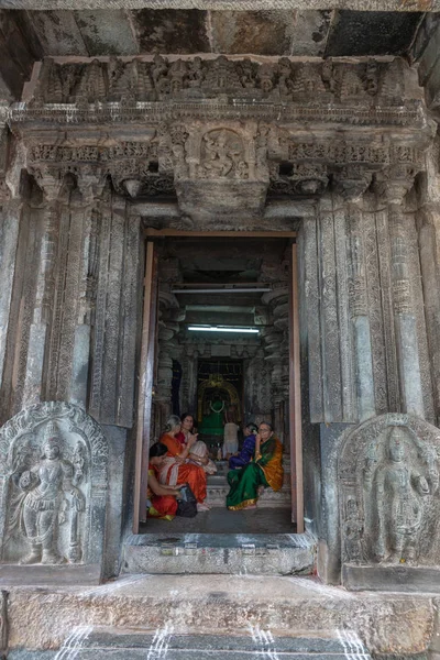 印度卡纳塔克邦的 Belur 2013年11月2日 Chennakeshava 窥视通过入口到灰色的石头安迪拉尔圣所 五名穿得五颜六色的妇女等待阿比什卡仪式开始 女神雕像在后面 — 图库照片