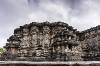 Belur, Karnataka, Hindistan - 2 Kasım 2013: Chennakeshava Tapınağı. Gri taş blok mavi yamalar ile beyaz gökyüzü altında Kesava Tapınağı. Heykeller duvarlar ve sütunlar üzerinde bereket.