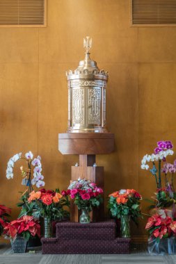Garden Grove, Kaliforniya, ABD - 13 Aralık 2018: Crystal İsa Katedrali. Kahverengi ahşap duvar karşı altın çadır mübarek Sacramet Şapel. Birçok çiçek ön.