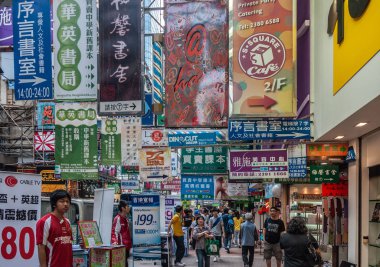 Hong Kong, China  - May 13, 2010: Kowloon mainland Section. Colorful commercial sign, print and lights, English, Mandarin and Kantonese, overkill on Nathan shopping street. Plenty of pedestrians.