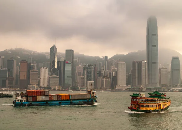 もっと暗い霧の空の下で国際金融センターと香港島 2010 スカイライン コンテナー船 サンパン スタイルの Watertours 川クルーズ ビクトリア ハーバーのボートの前 — ストック写真