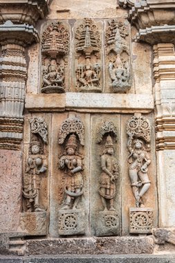 Belur, Karnataka, Hindistan - 2 Kasım 2013: Chennakeshava Tapınağı. Büyük Kahverengi duvar taş yan panel heykel, üst sıra, Vishnu ve iki eşleri, alt sıra, Shilabalikas, dans eden kızlar.