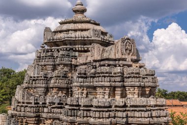 Belavadi, Karnataka, Hindistan - 2 Kasım 2013: Veera Narayana Tapınağı. Mavi gökyüzünde ağır cennet karşı üç Vimana kulelerden birini. Bazı yeşil bitki örtüsü.