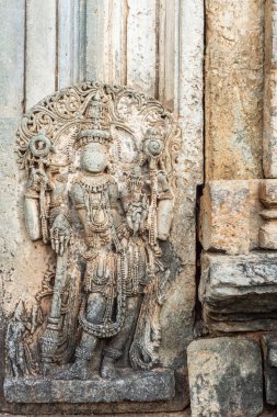 Belavadi, Karnataka, Hindistan - 2 Kasım 2013: Veera Narayana Tapınağı. Brown closeup taş heykel Lord karşı duvarın dışında giriş holü sanctuary için ayarla Vishnu. Kısmen zarar görmüş.