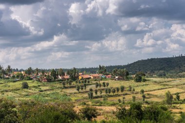 Kallahalli Kaval, Karnataka, Hindistan - 2 Kasım 2013: Yeşil yatay, hamlet ve onun kırmızı çatılar altında ağır cennet bir tarafta.