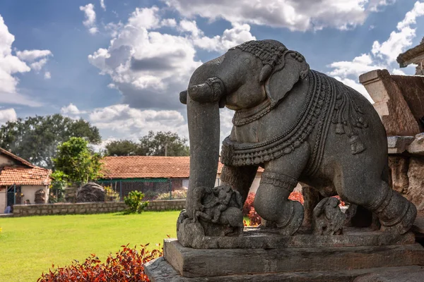 印度卡纳塔克邦贝拉瓦迪 2013年11月2日 Veera Narayana 在台阶上的灰色石头大大象雕像的特写镜头 云景下邻近房屋的红色屋顶 绿草坪 — 图库照片