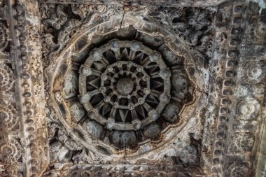 Belavadi, Karnataka, Hindistan - 2 Kasım 2013: Veera Narayana Tapınağı. Canavar yüzler ve bir yıldız şekli gri taş heykel Mandapam, tavanda dairesel mandala set gösterir.