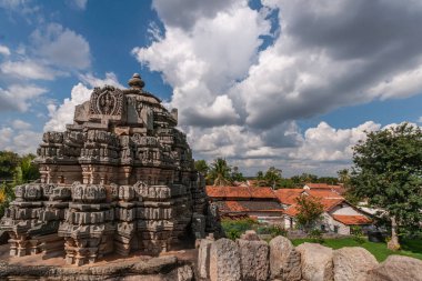 Belavadi, Karnataka, Hindistan - 2 Kasım 2013: Veera Narayana Tapınağı. En iyi kulenin birinde üç kahverengi taş Vimanams cennet altında kompleks closeup. Komşu evler leyleklerin. Çatıda vurdu.