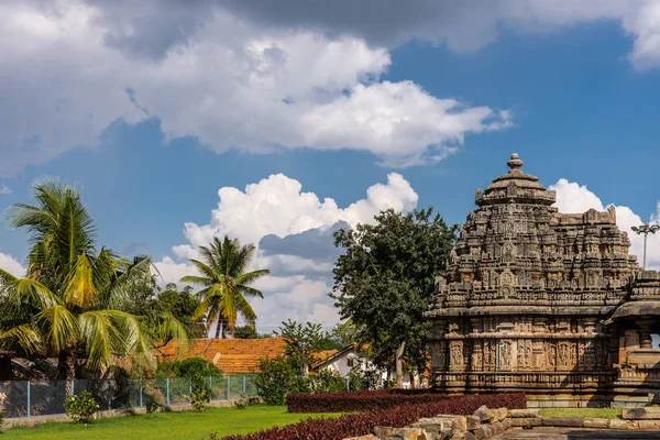 Belavadi カルナタカ インド 2013 ヴェーラ梵文和訳ナーラーヤナ神の寺 寺院の複合体の部分は重い Cloudscape と青い空の下で近隣の家の赤い屋根と緑豊かな環境の設定 — ストック写真