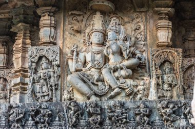 Halebidu, Karnataka, Hindistan - 2 Kasım 2013: Hoysaleşvara Tapınağı, Shiva. Heykel tarafındaki ana sığınak, nerede Lord Shiva ve Devi Parvati onun kucağına otur. Diğer rakamlar etrafında. Taş ile kahverengi geri gri.