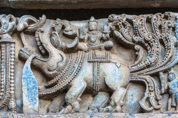 Halebidu カルナタカ インド 2013 Hoysaleswara の寺院のシヴァ神 象と人間の青みがかった石といくつかの茶色の背景の寺院の構造の側でトップの彫像のクローズ アップ — ストック写真