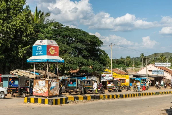 印度卡纳塔克邦哈莱比杜 2013年11月2日 霍伊萨拉什瓦拉寺附近的小镇街景 有小车交通 自行车和人 蓝天下的绿带 五颜六色的小企业外立面 交警哨所 — 图库照片