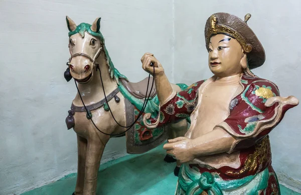 Homem com estátua de cavalo no templo taoísta Kwan Tai em Tai O, Hong K — Fotografia de Stock