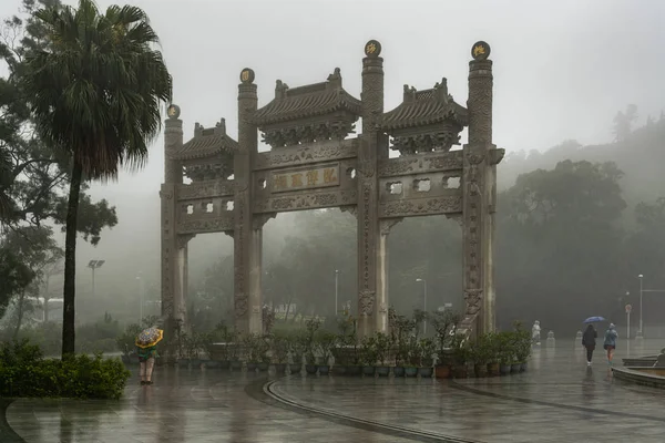 Puerta ornamental bajo fuertes lluvias en el Monasterio Budista Po Lin, H —  Fotos de Stock