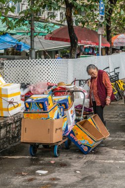 Woman collects carton at Tai Po Market, Hong Kong China.