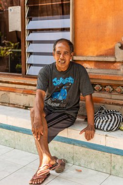 Klan bileşik oturan adam, Dusun Ambengan, Bali Endonezya.