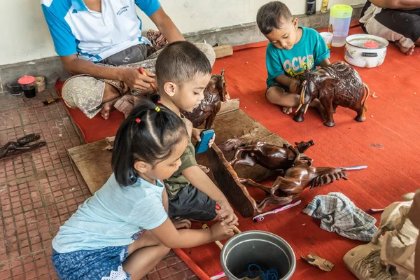 Drie kinderen werken bij Sari Pertiwi Wood carving Business, juga, — Stockfoto