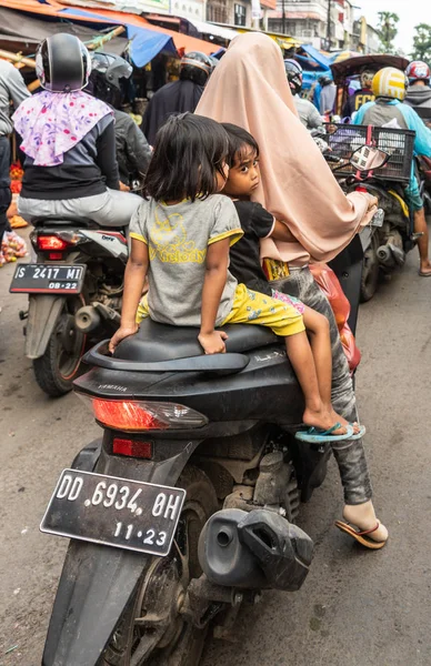 Makassa の Terong ストリートマーケットでバイクに乗っている2人の少女 — ストック写真