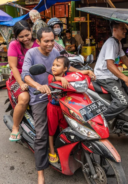 Dreiköpfige Familie auf Motorrad auf dem Wochenmarkt in Makassar — Stockfoto