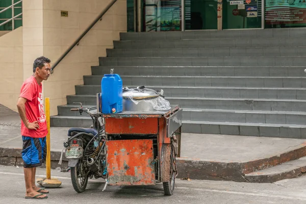 Ambulante vendedor de comida de rua com triciclo espera na rua do Homem — Fotografia de Stock