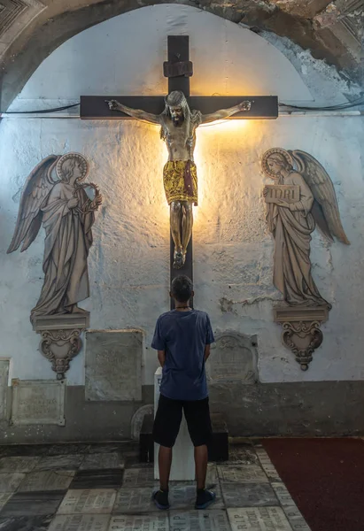 El hombre ora delante de Jesús en la Cruz en la iglesia de San Agustín , — Foto de Stock