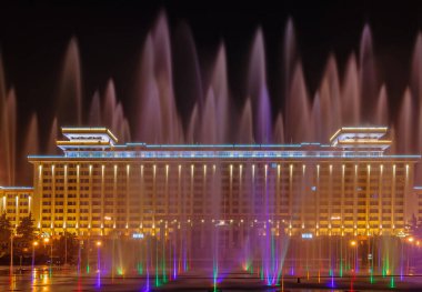 Xian, Çin - 1 Mayıs 2010: Kara Gece Sahnesi. Aydınlatılmış Shaanxi Halkı Hükümet Binası Renkli fıskiyelerin ardından görülüyor.