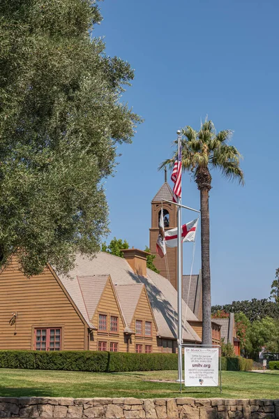 Los Olivos, California, ABD - 3 Eylül 2020: Vadi Kilisesi 'ndeki kahverengi ahşap St. Marks' ın portresi, mavi gökyüzünün altındaki yeşil parktaki çan kulesi. Bayrak ve bilgi posteri.