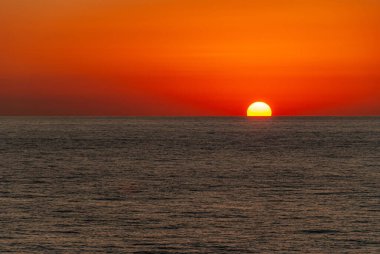 Cabo San Lucas, Meksika - 23 Kasım 2008: Yarı batık güneşin kızıl gökyüzü gün batımı Akşam Pasifik Okyanusu 'na.