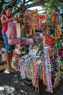 Acapulco, Meksika - 25 Kasım 2008: Old Downtown. Rengarenk olarak aşırı yüklü cep telefonu kabininin kapanışı geniş şeker seçimi ve küçük paketlenmiş günlük ihtiyaçlar sunuyor. Kadın satıcı mevcut..