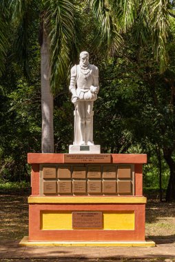 Leon, Nikaragua - 27 Kasım 2008: Eski Leon harabelerinde bulunan Park 'taki Francisco Hernandez de Cordoba heykelinin yakın çekimi. Kırmızı ve sarı kaidede beyaz heykel. Arkadaki yeşil yapraklar..