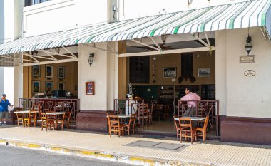 Leon, Nikaragua - 27 Kasım 2008: Central Park 'ın yanındaki El Sestea bar ve restorantın pencereleri açıldı. Kaldırımda tahta sandalyeler. Mevcut insanlar.