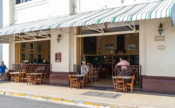 Leon, Nikaragua - 27 Kasım 2008: Central Park 'ın yanındaki El Sestea bar ve restorantın pencereleri açıldı. Kaldırımda tahta sandalyeler. Mevcut insanlar.